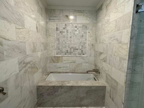 Luxury marble spa bathroom remodel with soaking tub, glass shower, and custom tile in Ocala, FL - CBC Construction Group
