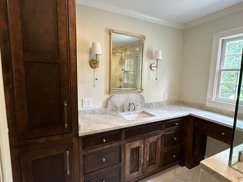 Custom bathroom vanity remodel with wood cabinetry, marble countertop, and updated lighting in Ocala, FL - CBC Construction Group