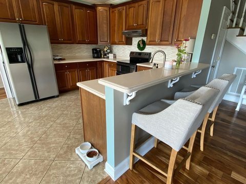 Warm wood kitchen renovation with custom cabinetry, breakfast bar, and stainless appliances in Ocala, FL - CBC Construction Group